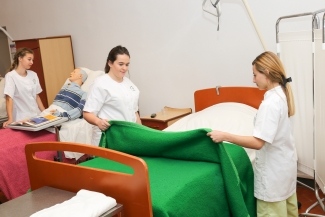 Des aides-soignantes faisant un lit 