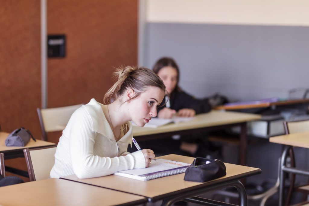 élève écrivant sur son cahier